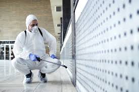 Hombre con traje Tyvek limpiando una habitación contaminada