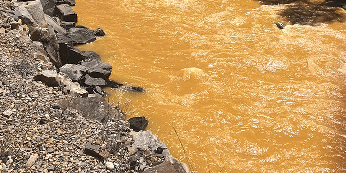 Vervuilde rivier stroomt oranje